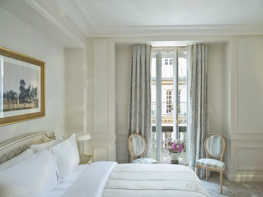 View from the right with the bed next to the flowers in front of the window, at Le Meurice, Paris