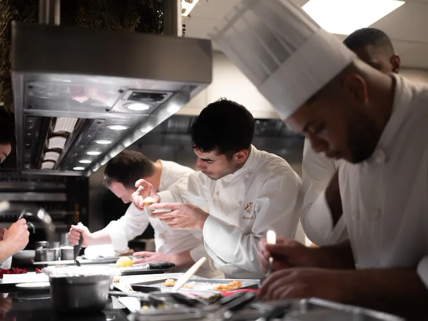 It is a photo of chefs very focused on the dressage of their plates in the kitchen, at Le Meurice, Paris.