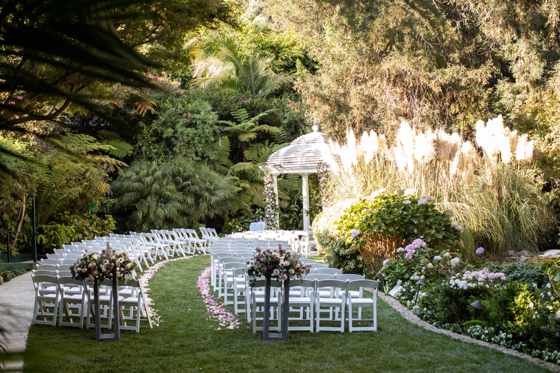 Outdoor wedding ceremony set up with white chairs on swan lake at Hotel Bel-Air