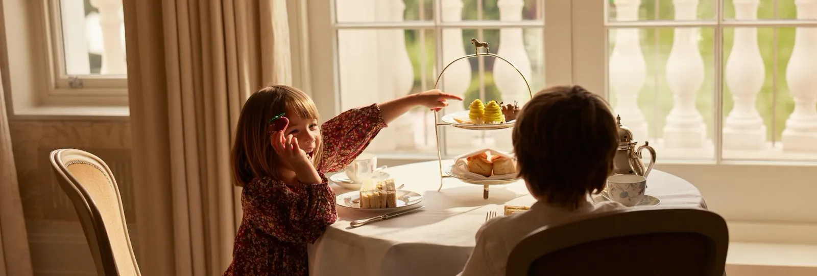 family relaxing and playing in room at Coworth Park