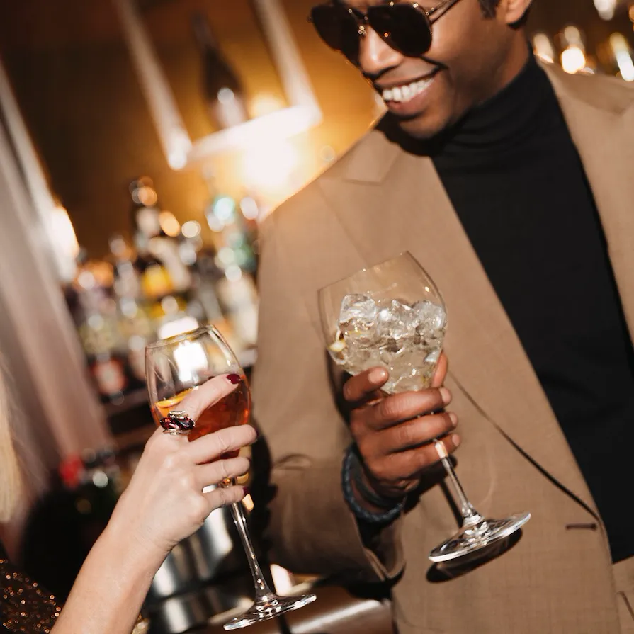 Detail of a male guest with sunglasses drinking during an event