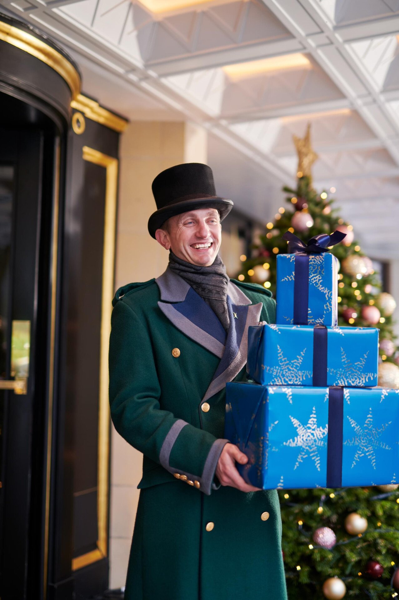The Dorchester Doorman carrying a Christmas Present