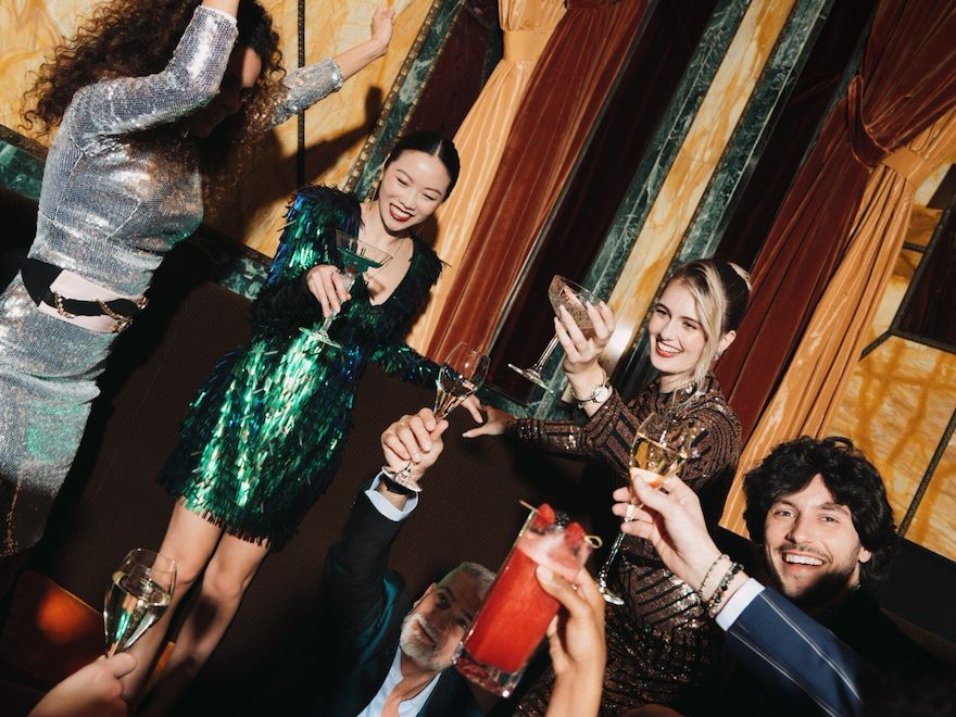 A group of people celebrating at Principe Bar and raising a toast