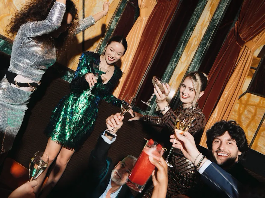 A group of people celebrating at Principe Bar and raising a toast