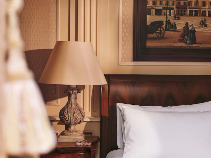 Detail of Premium Room showing partial bed and a lamp