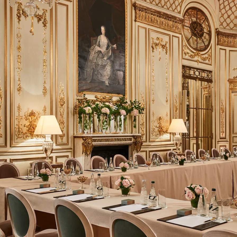 Salon Pompadour transformed into a U-shaped meeting room. On the table we have flowers, papers, pens and bottles of water, in Meurice, Paris.