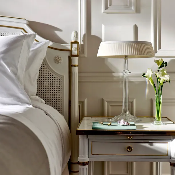 A few pieces of jewelery and a watch placed on the bed side table of a superior room. At Le Meurice, Paris.