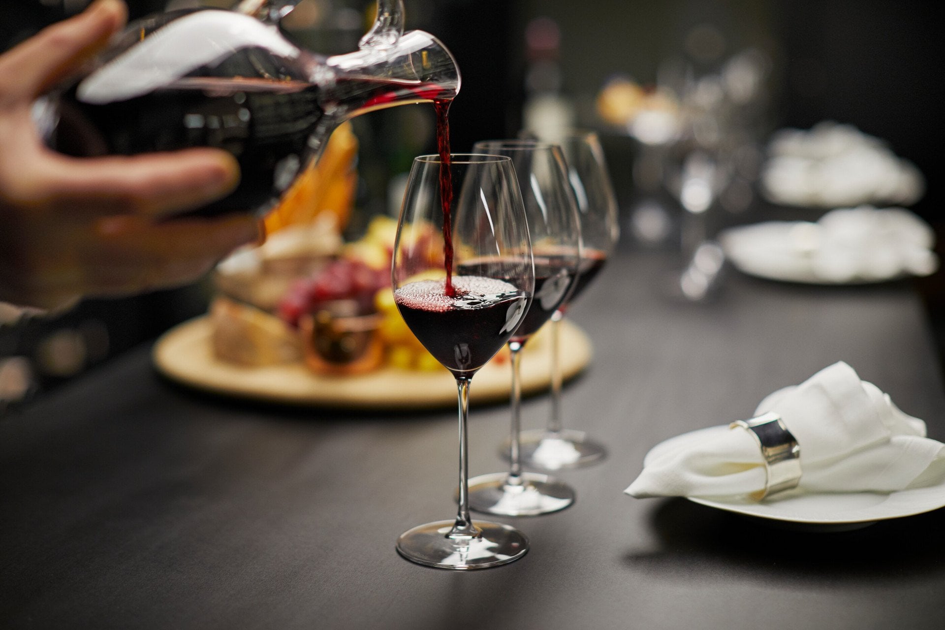 Red wine being poured into glaswarein the wine vault at the dorchester 