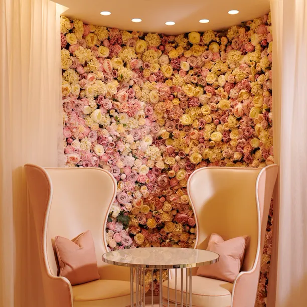 The Dorchester Spatisserie seating area with rose flower wall