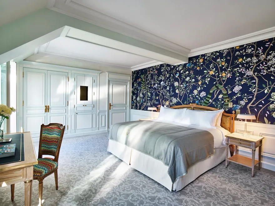 Overview of an executive room with balcony highlighting the dark blue hand painted wall with nature details. At Le Meurice, Paris.