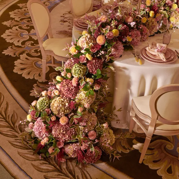 The Dorchester Gold and Silver event space set for an evening event with beautiful flower arrangement on the table