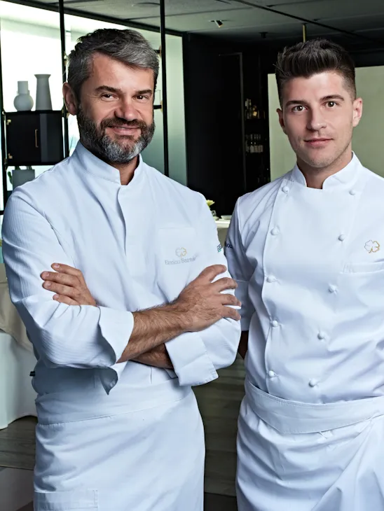 2 chefs standing in a restaurant.