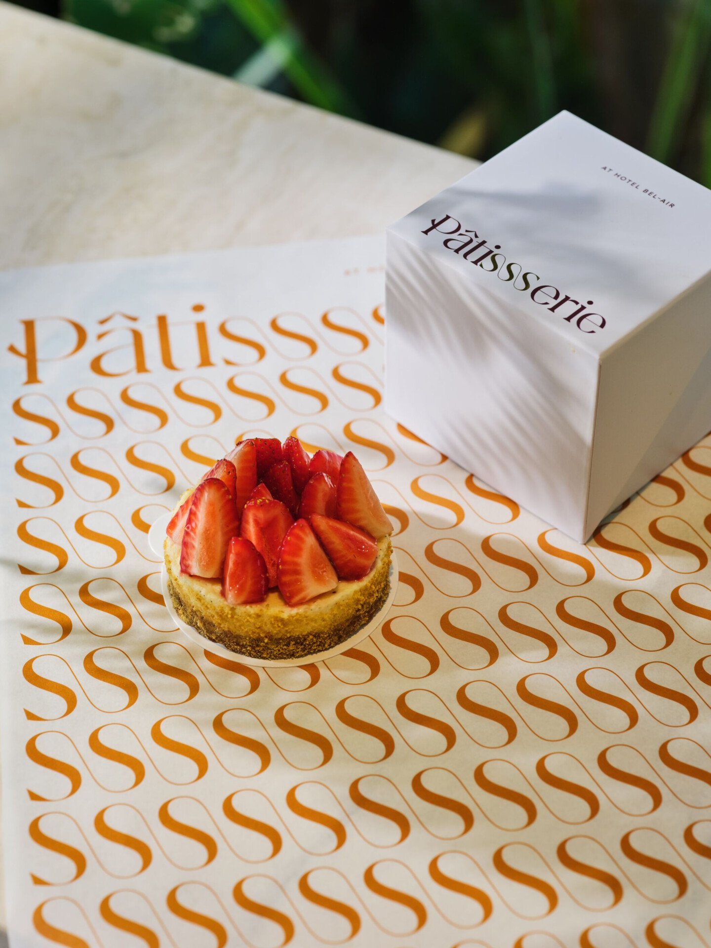 Seasonal cheesecake on top of Patisserie branded tissue paper and Patisserie branded box
