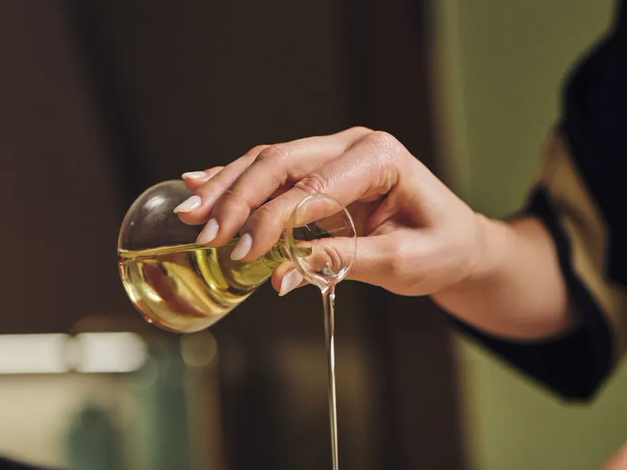 Spa therapist pouring massage oil on the back of a lying woman