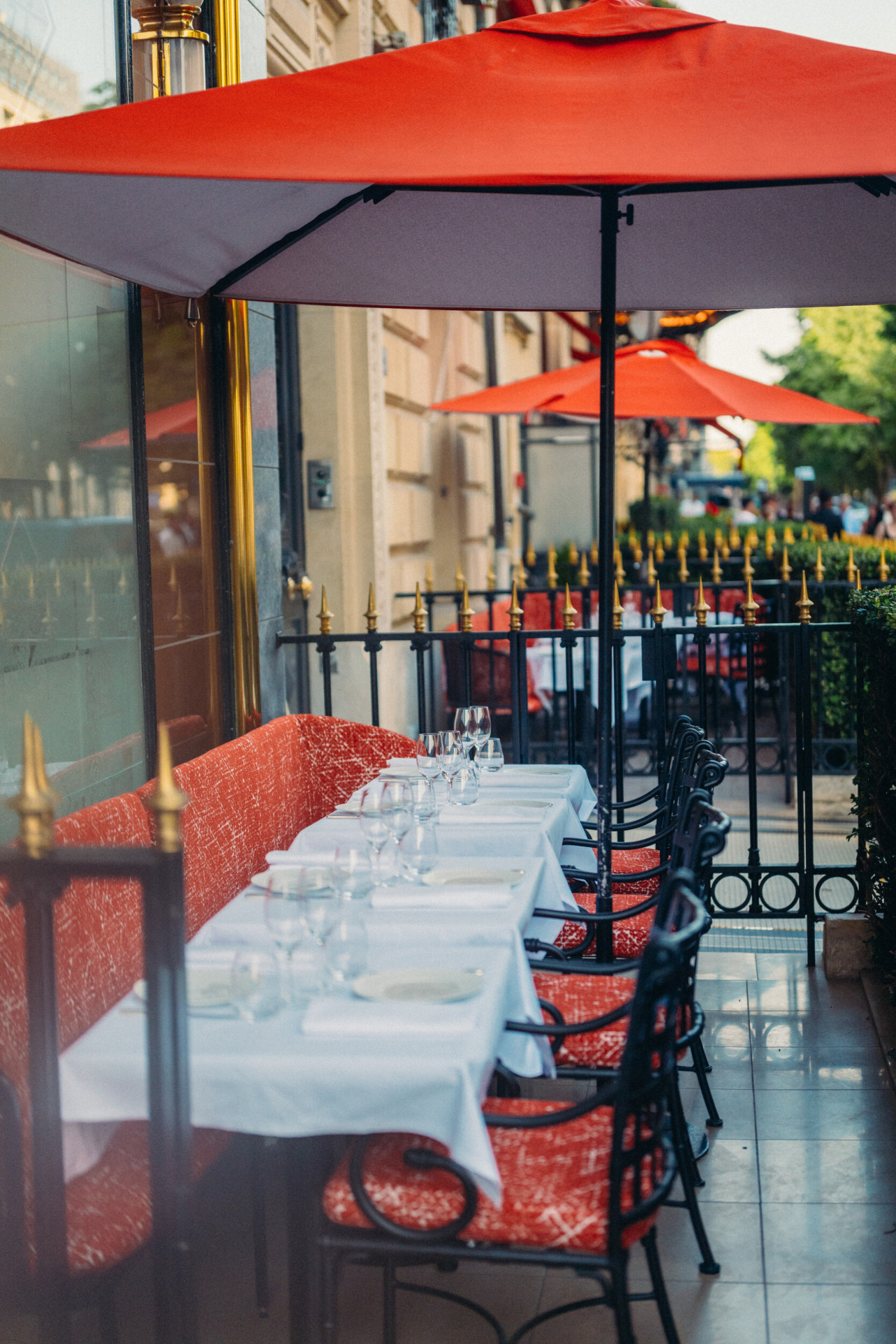 La terrasse du Relais Plaza avec ses tables dressées et ses parasols rouges Plaza, à l'hôtel Plaza Athénée, Paris