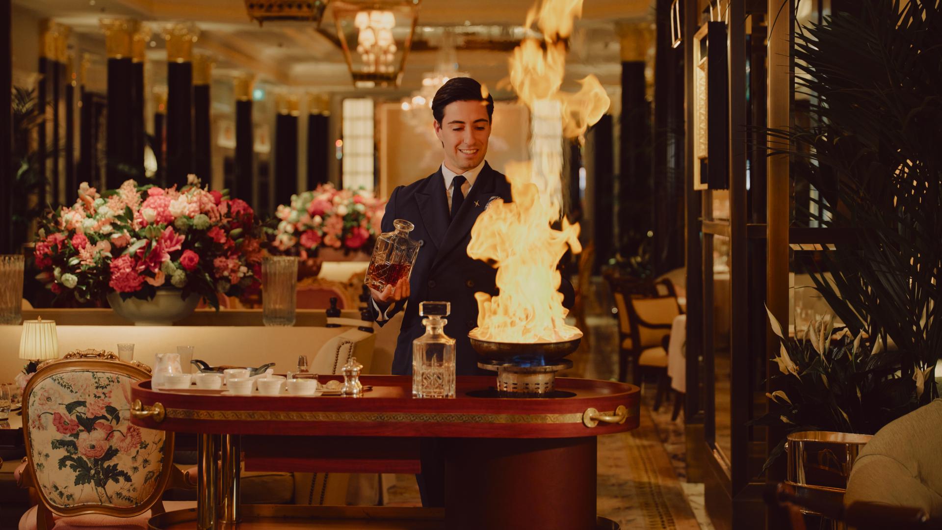 The Promenade after dark. Waiter making Steak Dianne 
