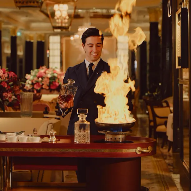 The Promenade after dark. Waiter making Steak Dianne