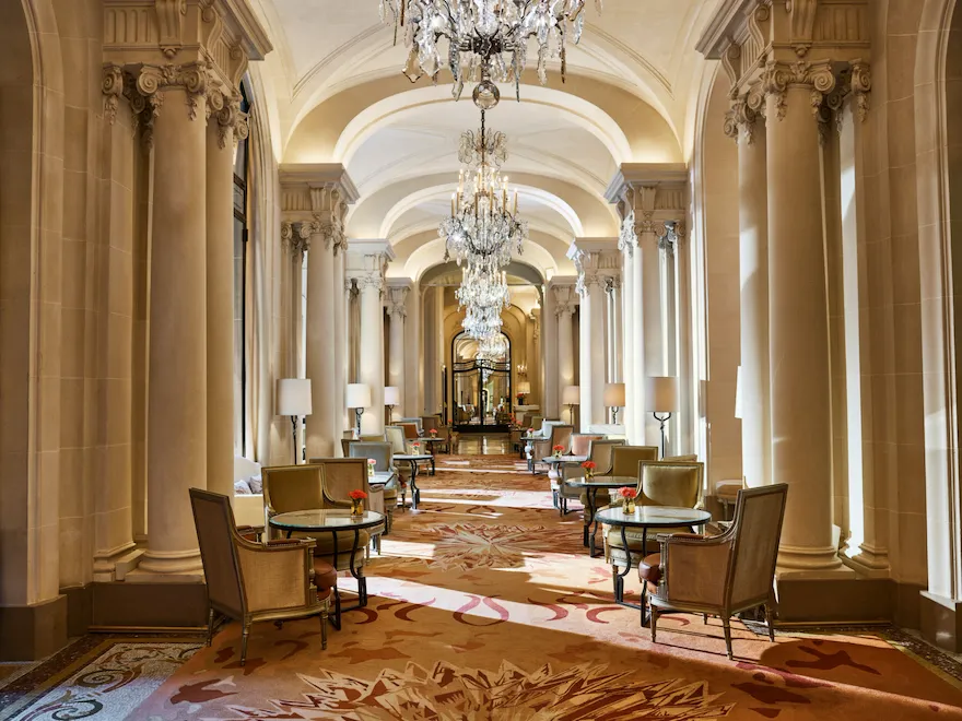 Corredor do restaurante La Galerie com seus lustres e suas mesas, no Hotel Plaza Athénée, Paris