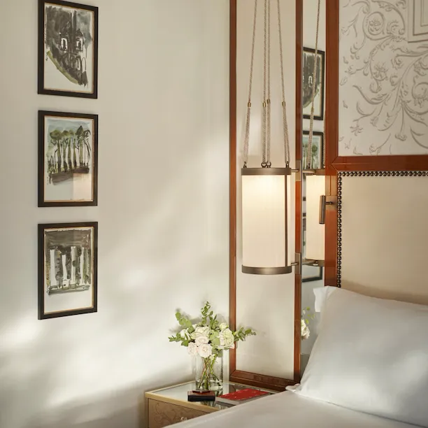 Bedroom detail of Prestige Suite with bouquet of flowers on night table at Hotel Eden, Rome