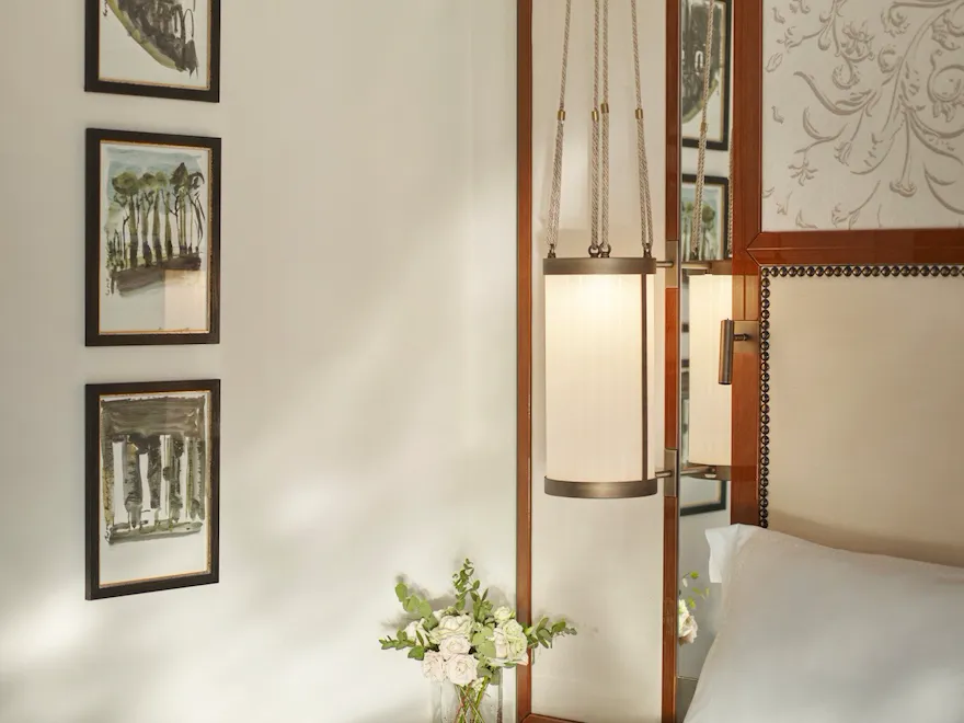 Bedroom detail of Prestige Suite with bouquet of flowers on night table at Hotel Eden, Rome