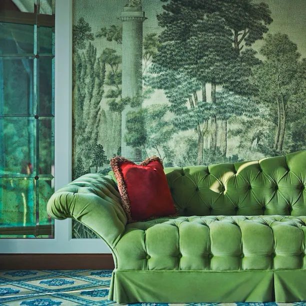 Green velvet sofa with red cushion in the second bedroom of Presidential Suite