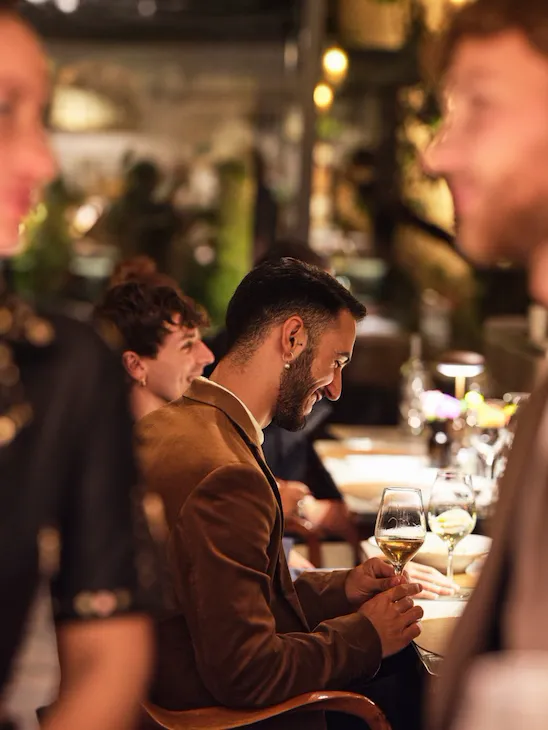 Close up of twosome at bar and people seated on the background seated at Il Giardino Ristorante