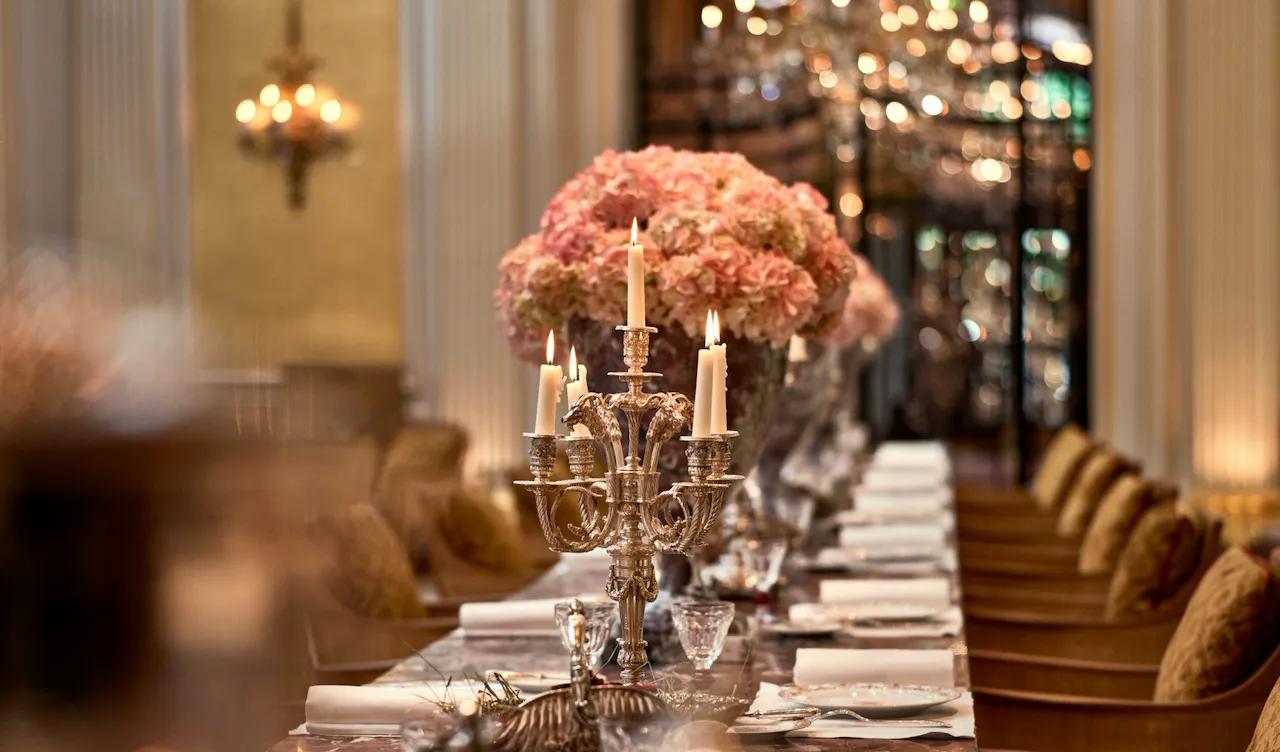 Jean Imbert au Plaza Athénée : la table centrale en marbre, agrémentée de fleurs roses et de chandeliers. A l'hôtel Plaza Athénée, Paris