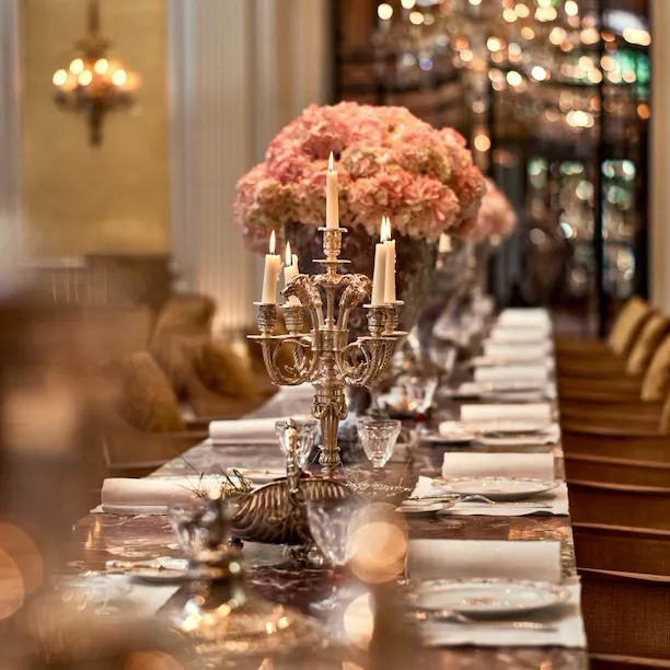Jean Imbert au Plaza Athénée : la table centrale en marbre, agrémentée de fleurs roses et de chandeliers. A l'hôtel Plaza Athénée, Paris