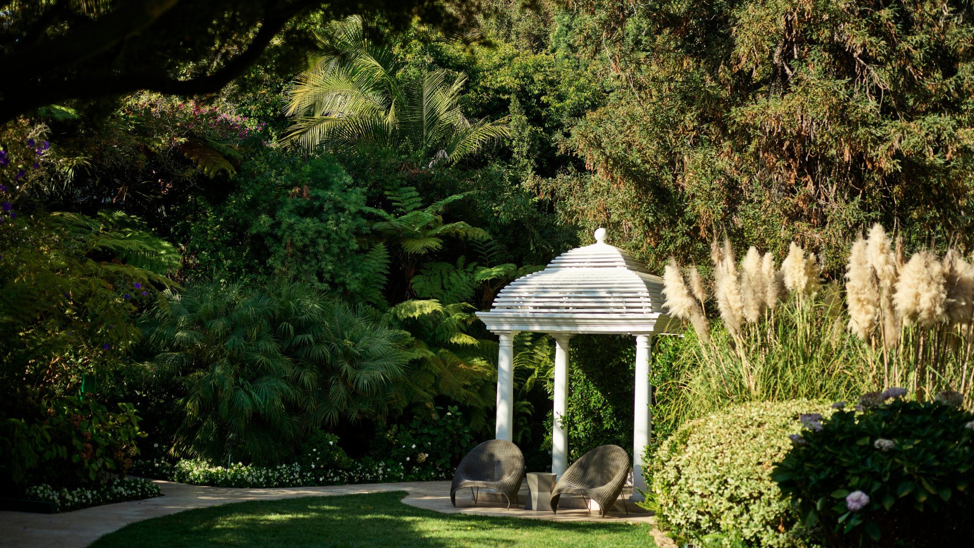 White gazebo on lawn next to swan lake at Hotel Bel-Air