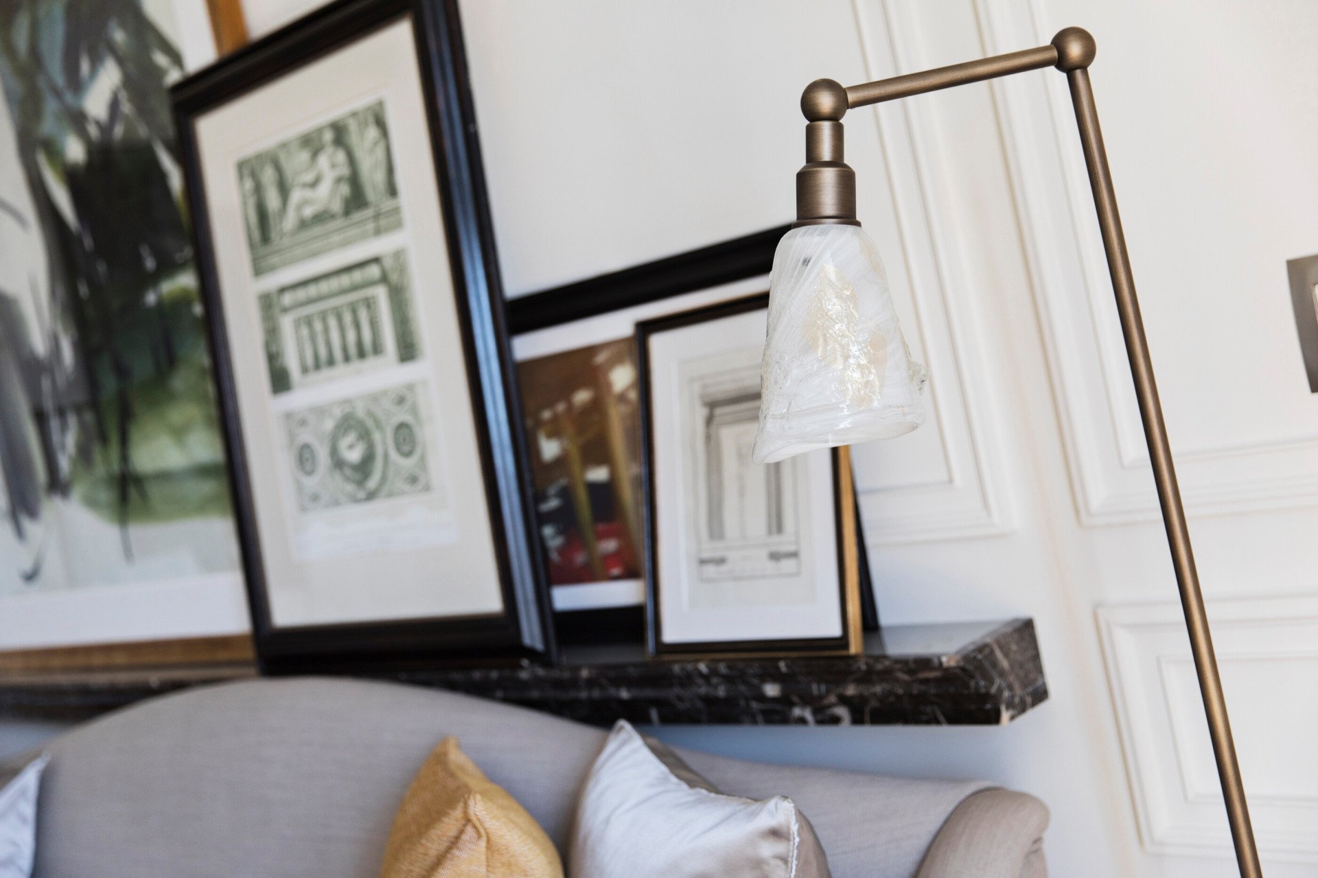 Detail of suite's living room with lamp, couch and paintings at Hotel Eden, Rome