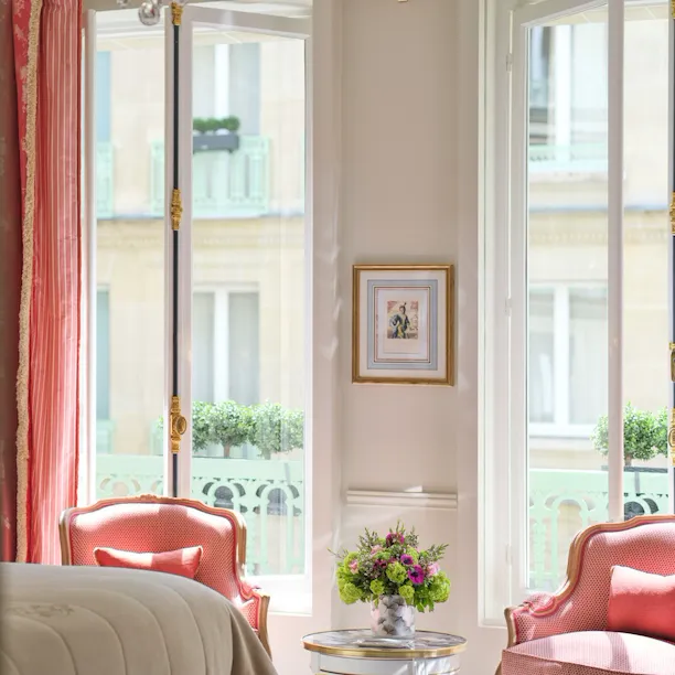 Realce de um quarto de luxo com vista para as cadeiras a condizer com o cortinado em frente às janelas, no Le Meurice, Paris