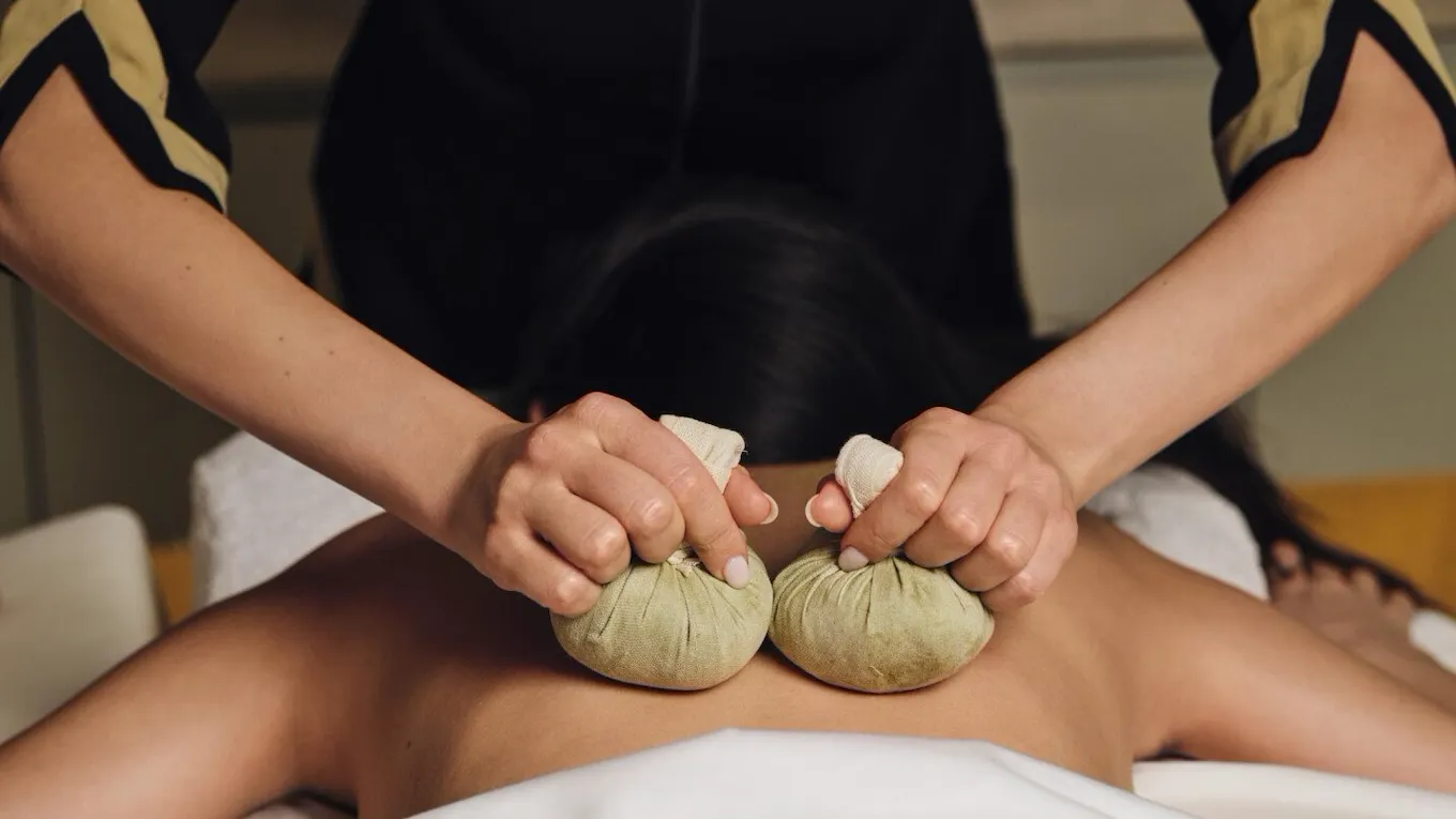 Spa therapist who is actively doing a hay treatment by Hobepergh