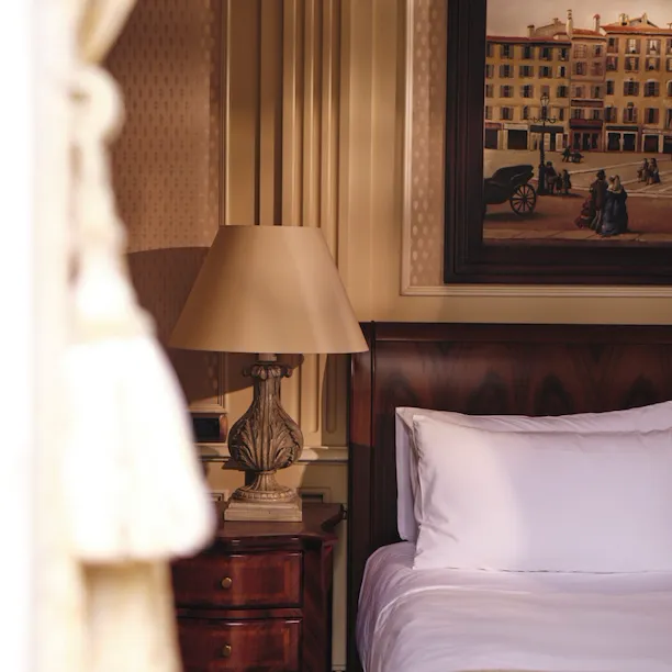 Detail of Premium Room showing partial bed and a lamp