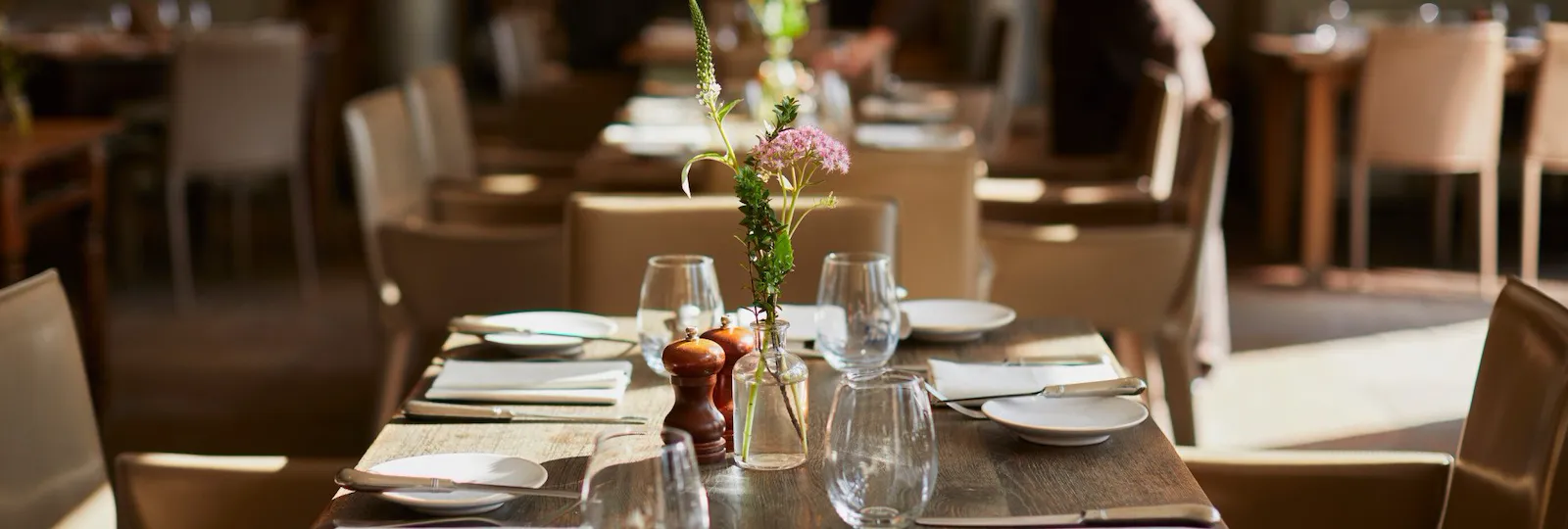 Tables in The Barn on a sunny day with waitress, Coworth Park, Ascot