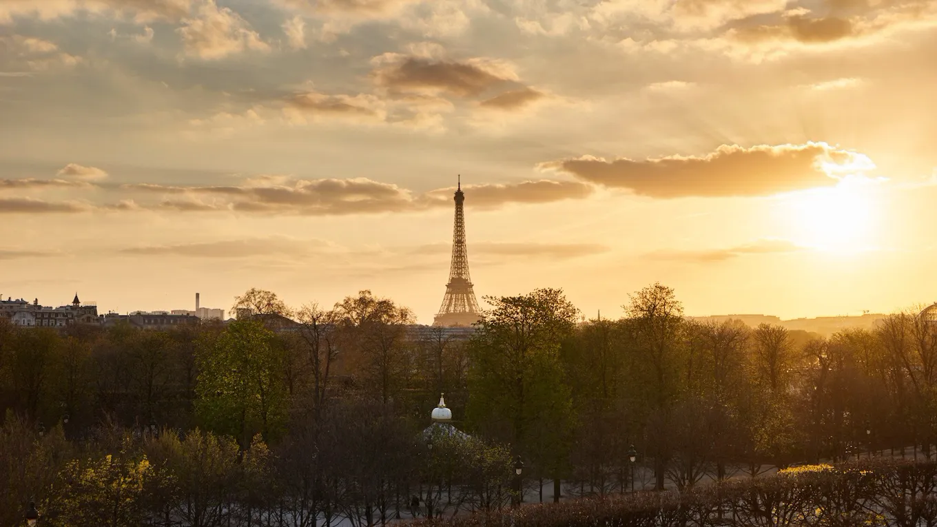 Distant view of the Eiffel tower at sunset with golden light from the Heritage Suite. At Le Meurice, Paris.