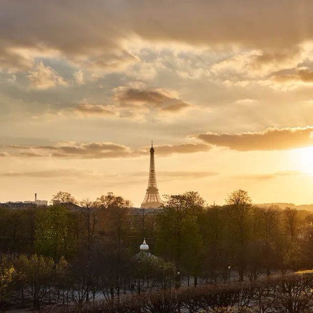 Vue lointaine sur la tour Eiffel au coucher du soleil avec lumière dorée depuis la Suite Héritage. Au Meurice, Paris.