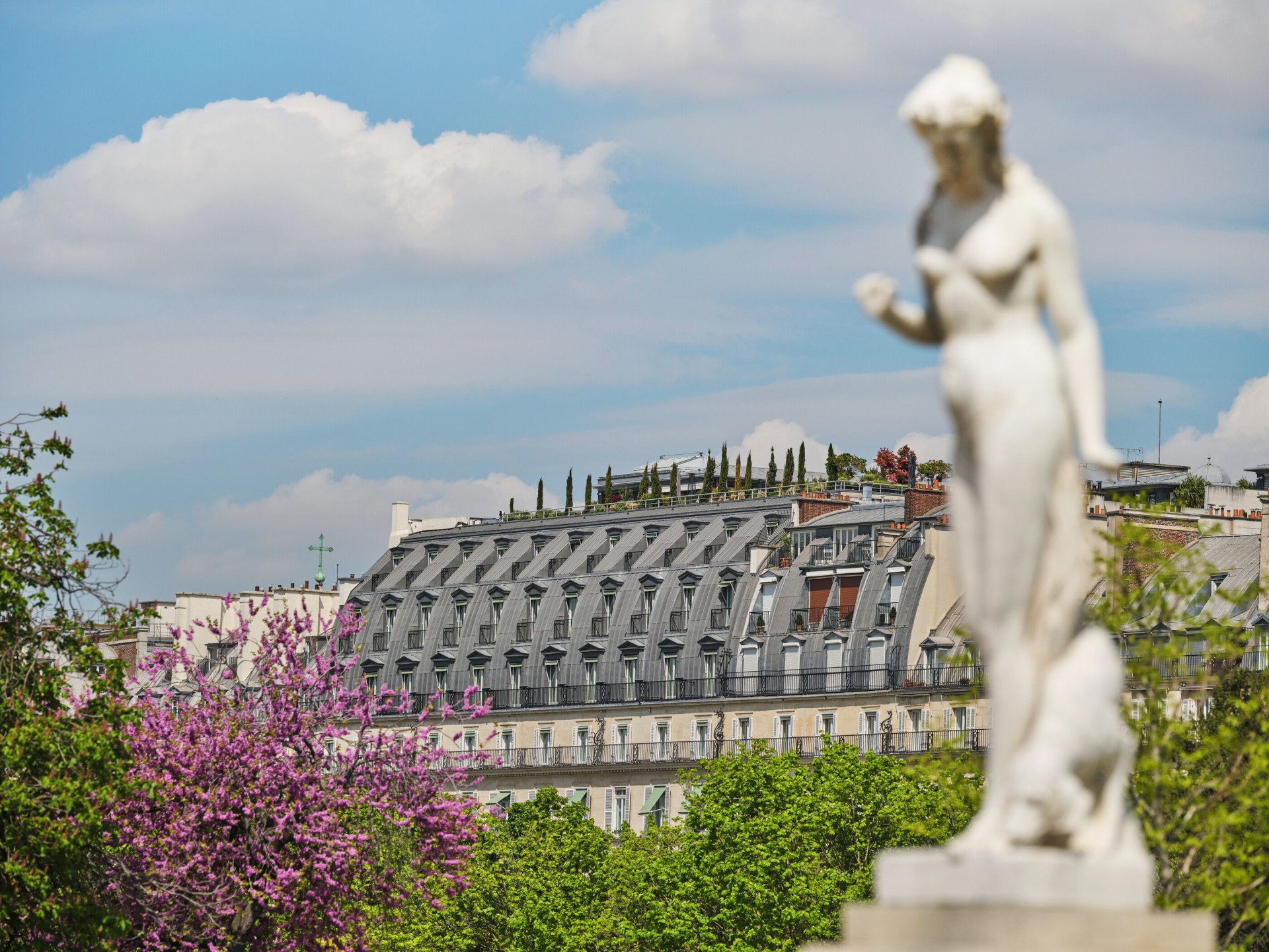 Vue sur le toit du Meurice avec des arbres et une sculpture devant, au Meurice, Paris