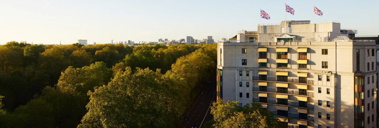 The Dorchester building exterior at sunset next to Hyde Park, London