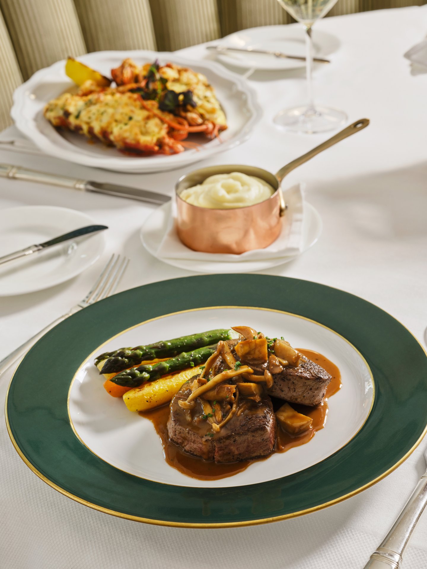 Elegant table setting with plated main course and additional dish in a bright dining room
