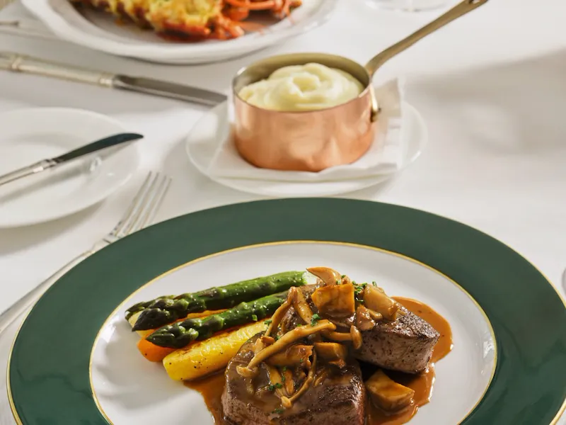 Elegant table setting with plated main course and additional dish in a bright dining room