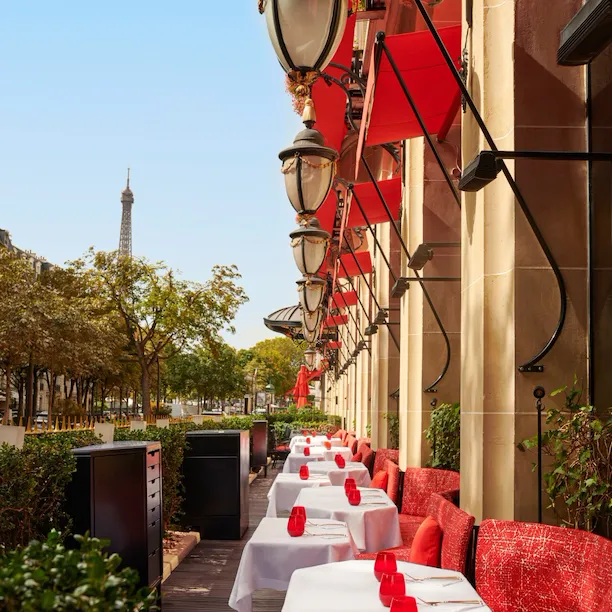 Foto de La Terrasse Montaigne com mesas rebatíveis e assentos vermelhos emblemáticos