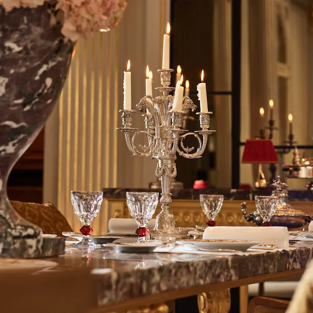 Marble table of the Jean Imbert au Plaza Athénée dining room, drawned up with crystal glasses and silver candleholder. At Hotel Plaza Athénée Paris.
