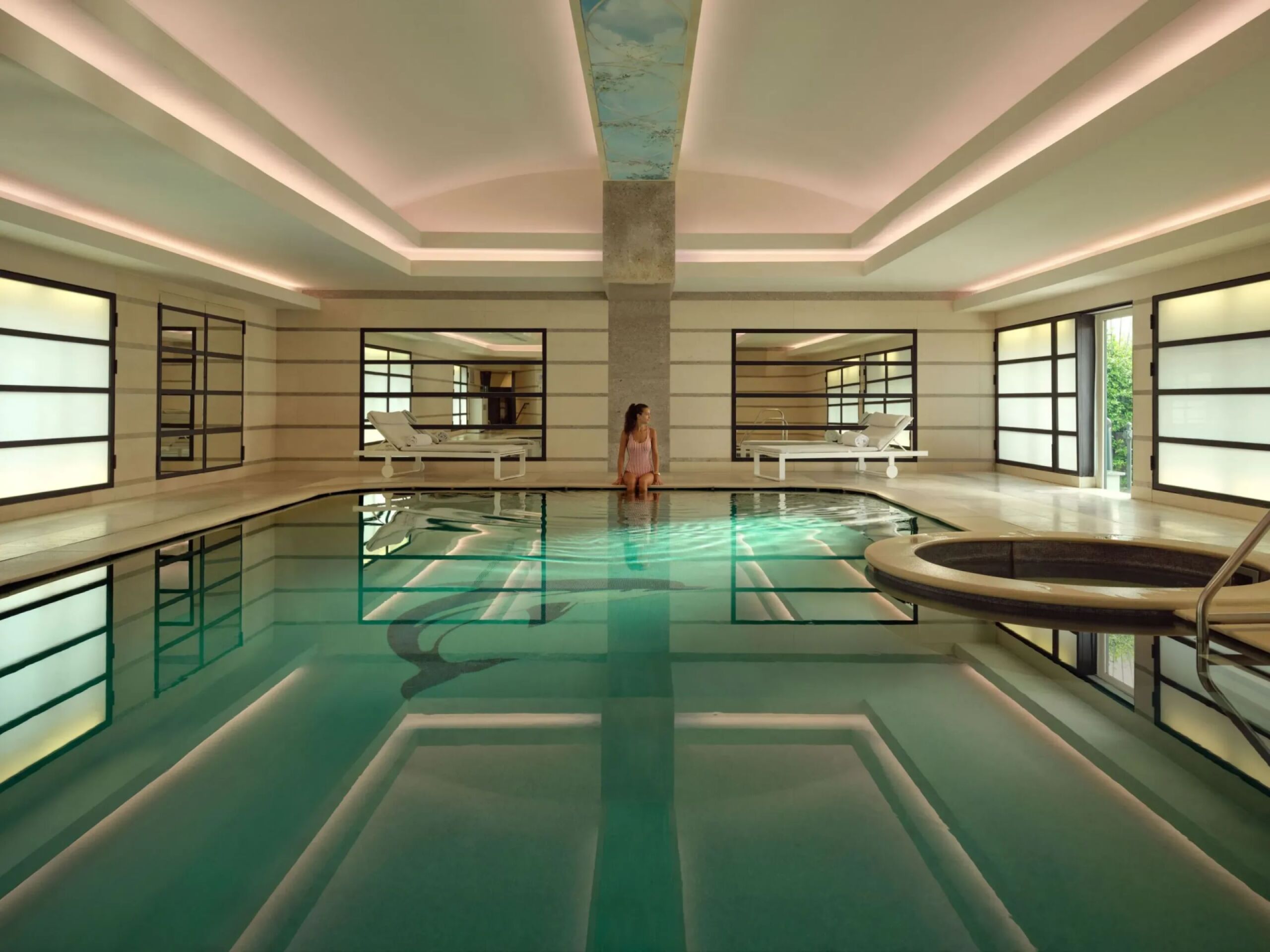 Club 10 swimming pool landscape view with a woman sitting by the poolside