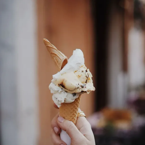 Mano che tiene un cono di gelato