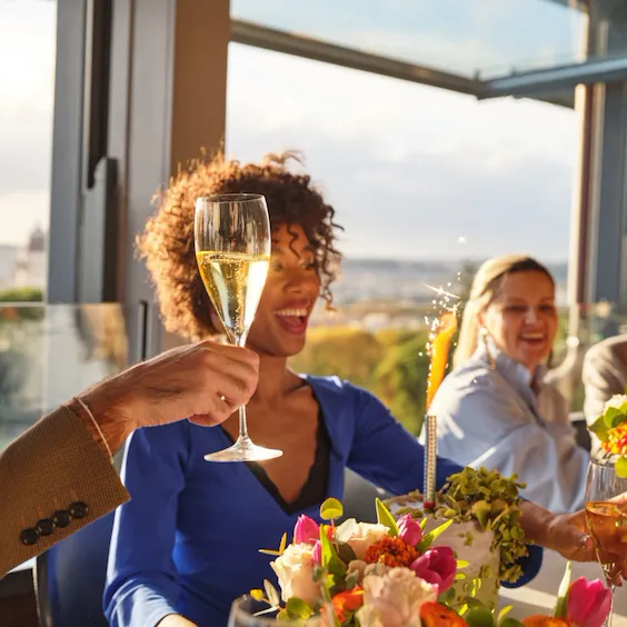 persone sedute ad un tavolo de La Terrazza che festeggiano un compleanno con torta e brindando