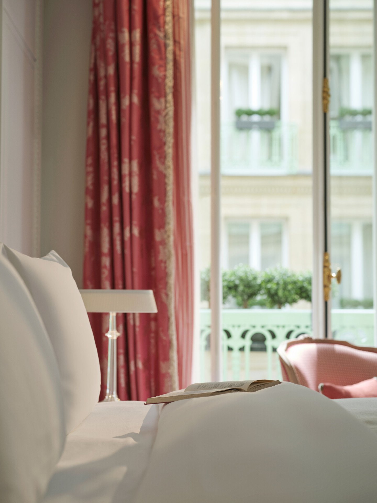 Une chambre de luxe avec en premier plan le lit et en fond le rideau et la fenêtre, au Meurice, Paris