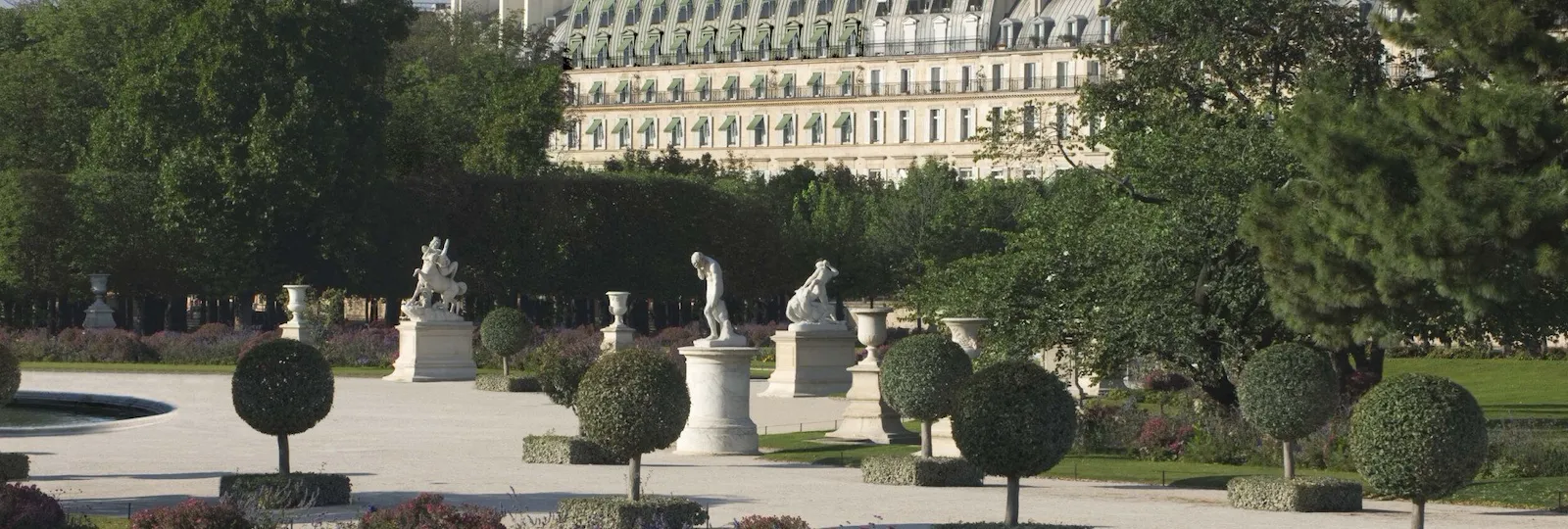 Distant view of the hotel from the Tuileries Garden point of view, showing the top part of the façade and the green shades, at the Tuileries Gardens, Paris.