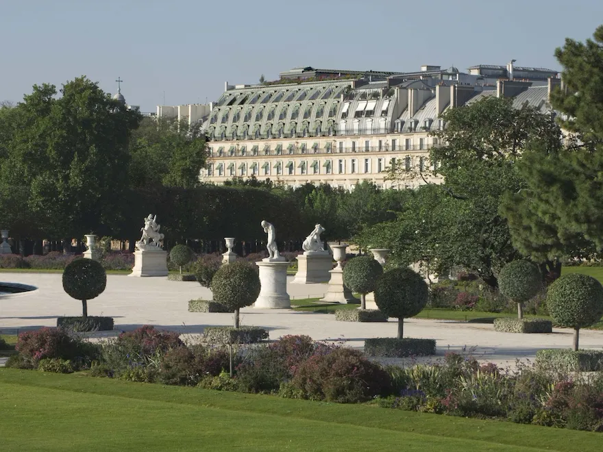 Vue lointaine de l’hôtel du point de vue du jardin des Tuileries, montrant la partie supérieure de la façade et les tons verts, au jardin des Tuileries, Paris.