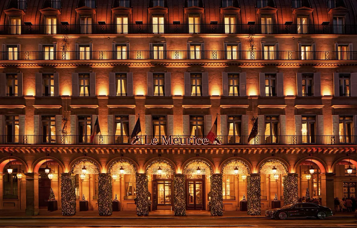 Hotel by night with lights on the facade and Christmas decorations illuminated on the arcades, at Le Meurice, Paris