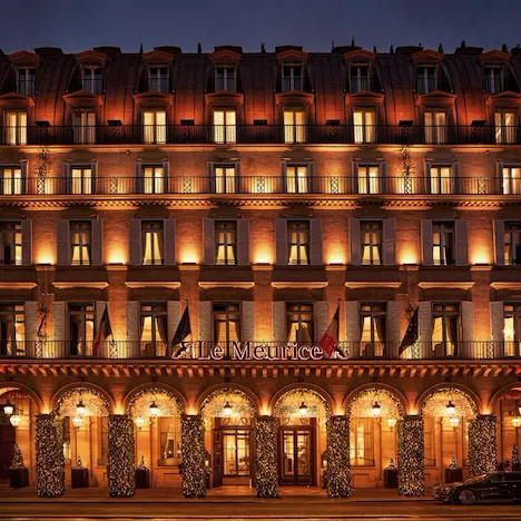 Hôtel de nuit avec lumières sur la façade et décorations de Noël illuminées sur les arcades, au Meurice, Paris
